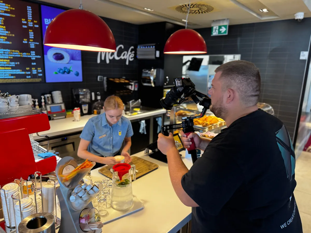 Natáčanie v McCafé: kameraman s gimbalom sníma baristku pri príprave